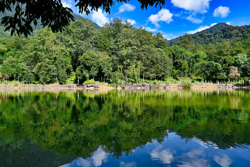 Kathok Lake Yuksom - serene sacred lake with mirror reflections of forest and mountains in West Sikkim